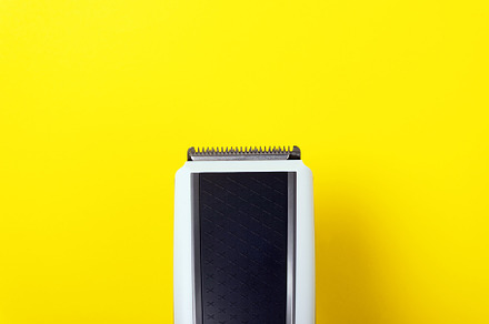 Top view of a black and white electric hair clipper on a bright