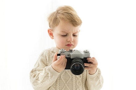 A little boy with a camera in his ha