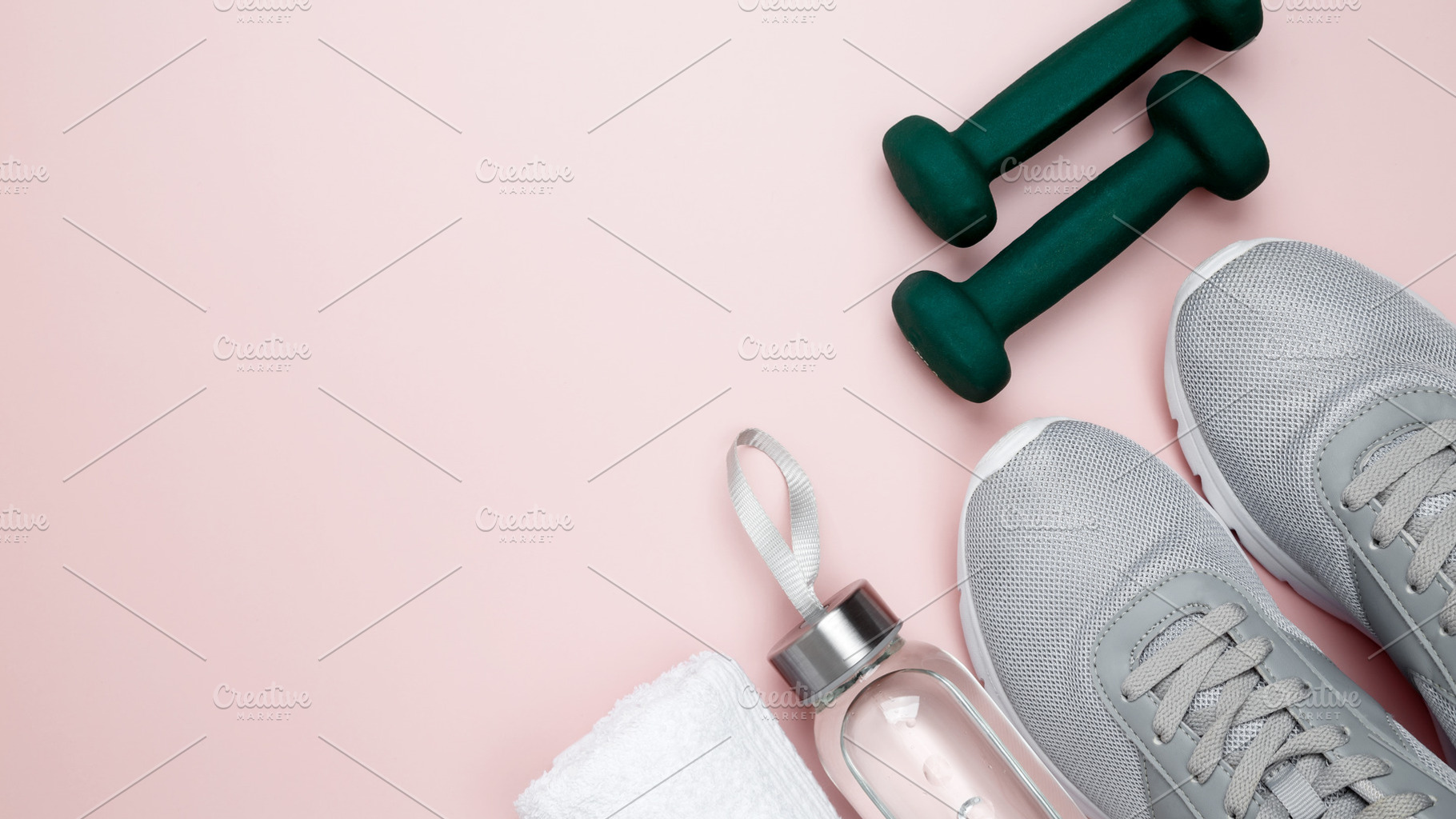 Gray sports shoes, green dumbbells, water bottle, and white towel on a pastel p, a Photo by matucha