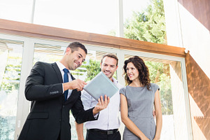 Real-estate agent showing couple new home, a Photo by wavebreak