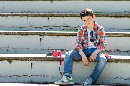 Casual boy sitting on steps with headphones and sunglasses., a Person Photo by RF Images