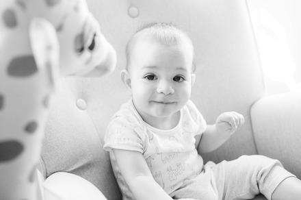 Portrait of a nine month old baby with a stuffed giraffe sitting in a rocking c, a Person Photo by rubenchase