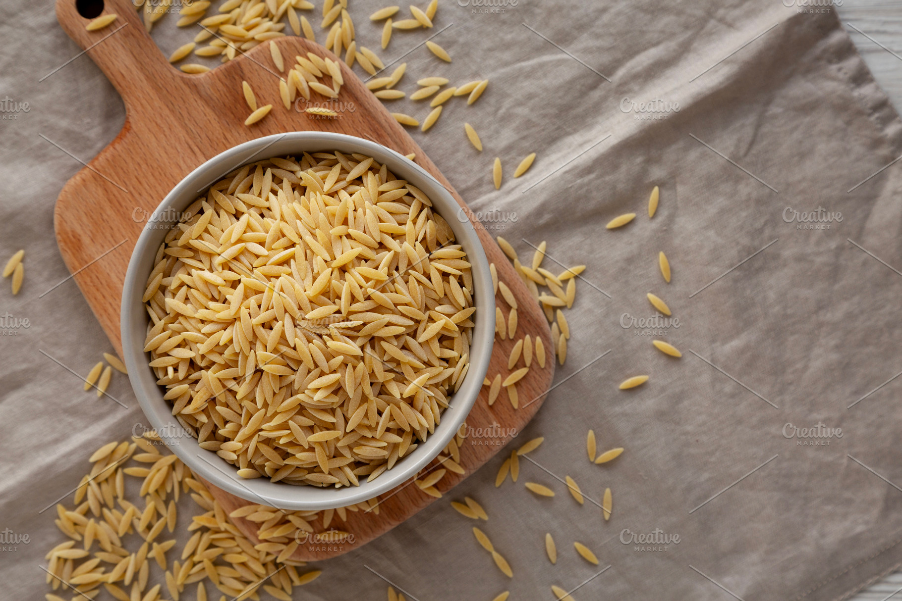 Organic Dried Orzo Pasta in a Bowl, top view. Space for text., a Food & Drink Photo by LiudmylaChuhunova