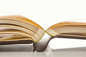 Open photo album showing thick pages and binding on white background, an Abstract Photo by Antonio Gravante Market