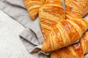 Freshly baked croissants resting on a gray cloth napkin, a Food & Drink Photo by Olena Rudo