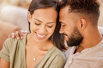 Black couple, happy and love on sofa in closeup, living room and hug for bonding, care and together. Woman, man and happiness for embrace, smile and romantic for relationship in home, house or lounge, a Photo by Peopleimages.com