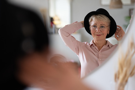 Caucasian woman trying on hat containing woman, fashion, and person, a Person Photo by Koldunova