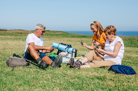 Adult family playing cards sitting on a blanket during an excursion, a Holiday Photo by davidpereiras