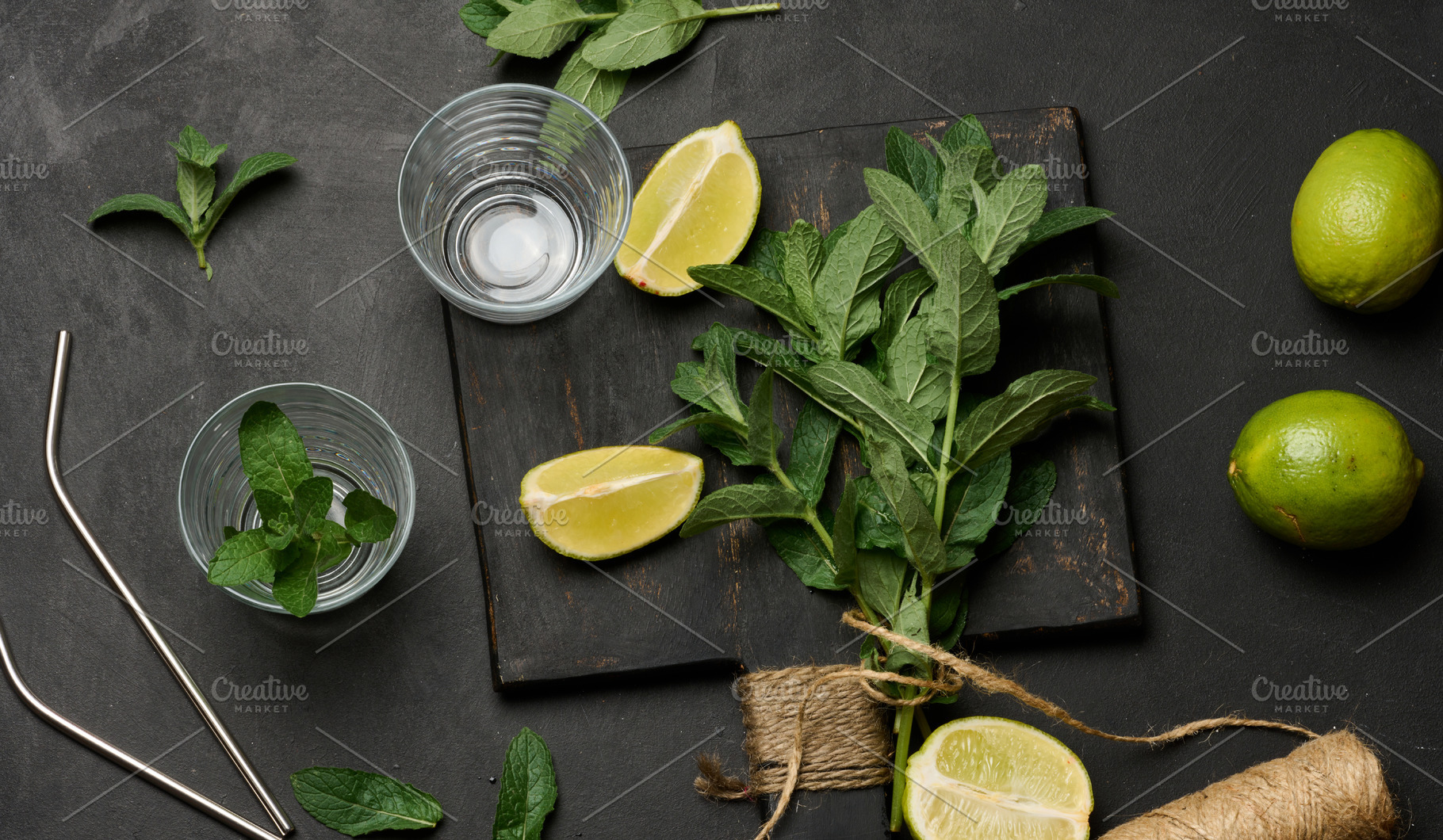 Bunch of fresh green mint on wooden board and lime wedges, glass, a Food & Drink Photo by ndanko