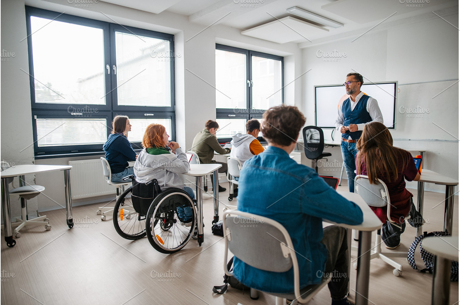 Teacher in inclusive classroom, a School & Education Photo by HalfPoint