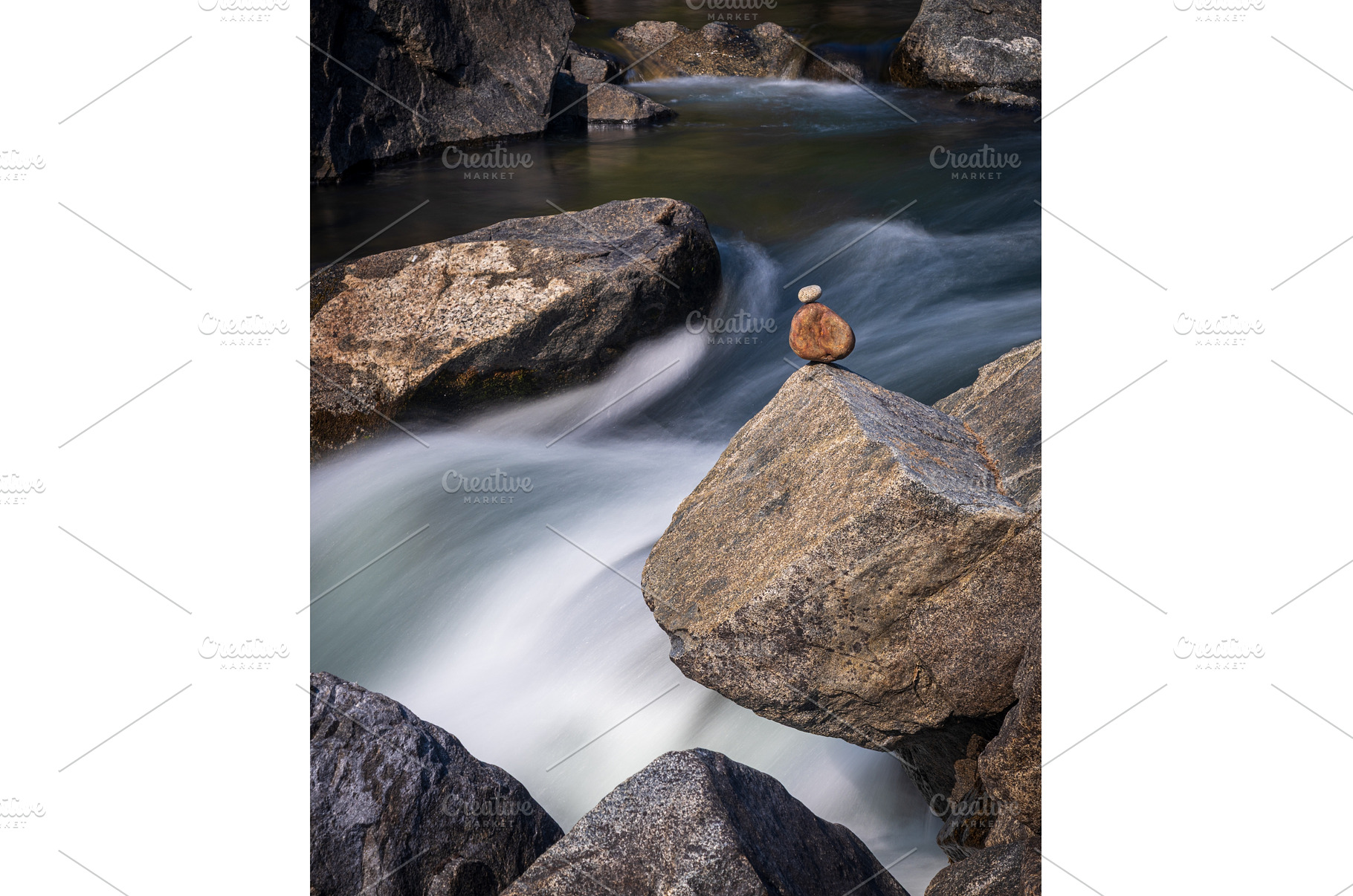 Pebbles balanced on rocks in raging, a Nature Photo by Backyard Stock