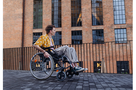 Gen Z boy in a wheelchair in the, an Architecture Photo by HalfPoint