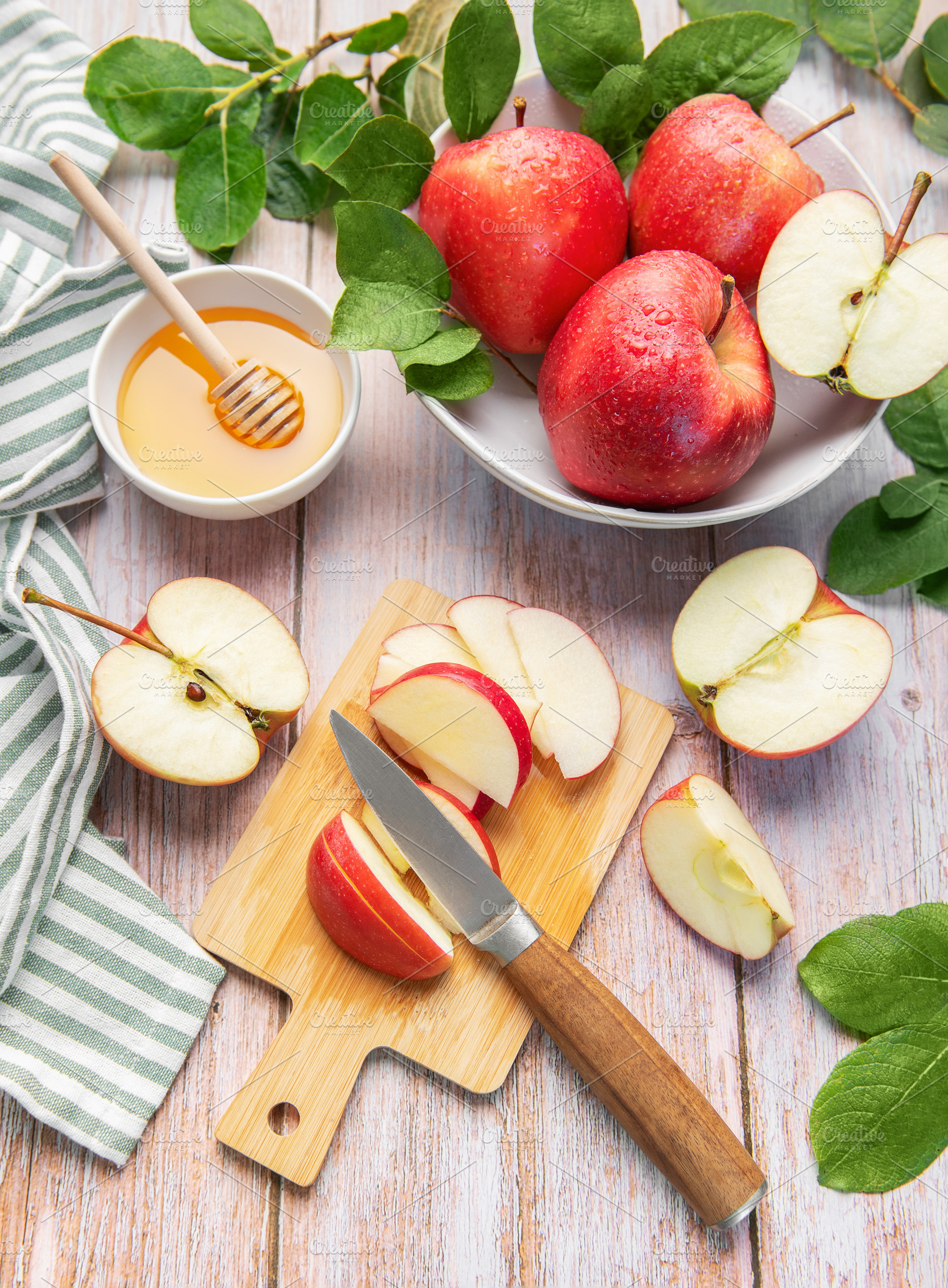 Red apples, honey, and knife on cutting board, a Food & Drink Photo by Olena Rudo