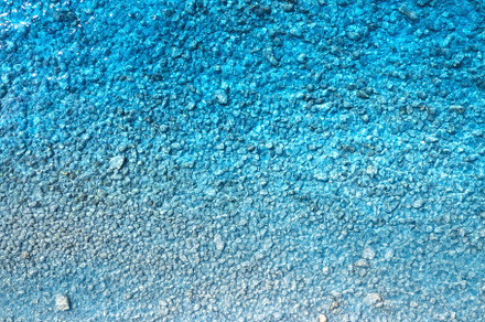 Sea background. Aerial view of clear blue sea, stones in water, a Nature Photo by den-belitsky