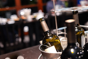 close-up of red wine bottle in ice bucket on romantic table, bac, a Food & Drink Photo by Casanowe-studio