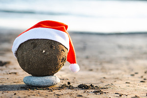 Christmas sand sculpture with Santa hat on the beach, a Holiday Photo by etorres69