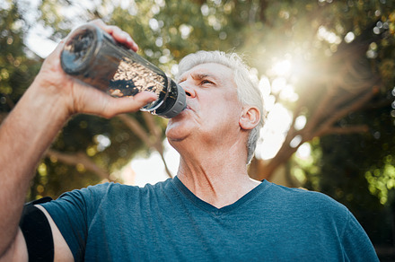 Water, nature fitness and senior man training for heart health in a park for body health in summer. Elderly athlete or runner with drink after cardio workout, running or outdoor sports exercise, a Photo by Peopleimages.com