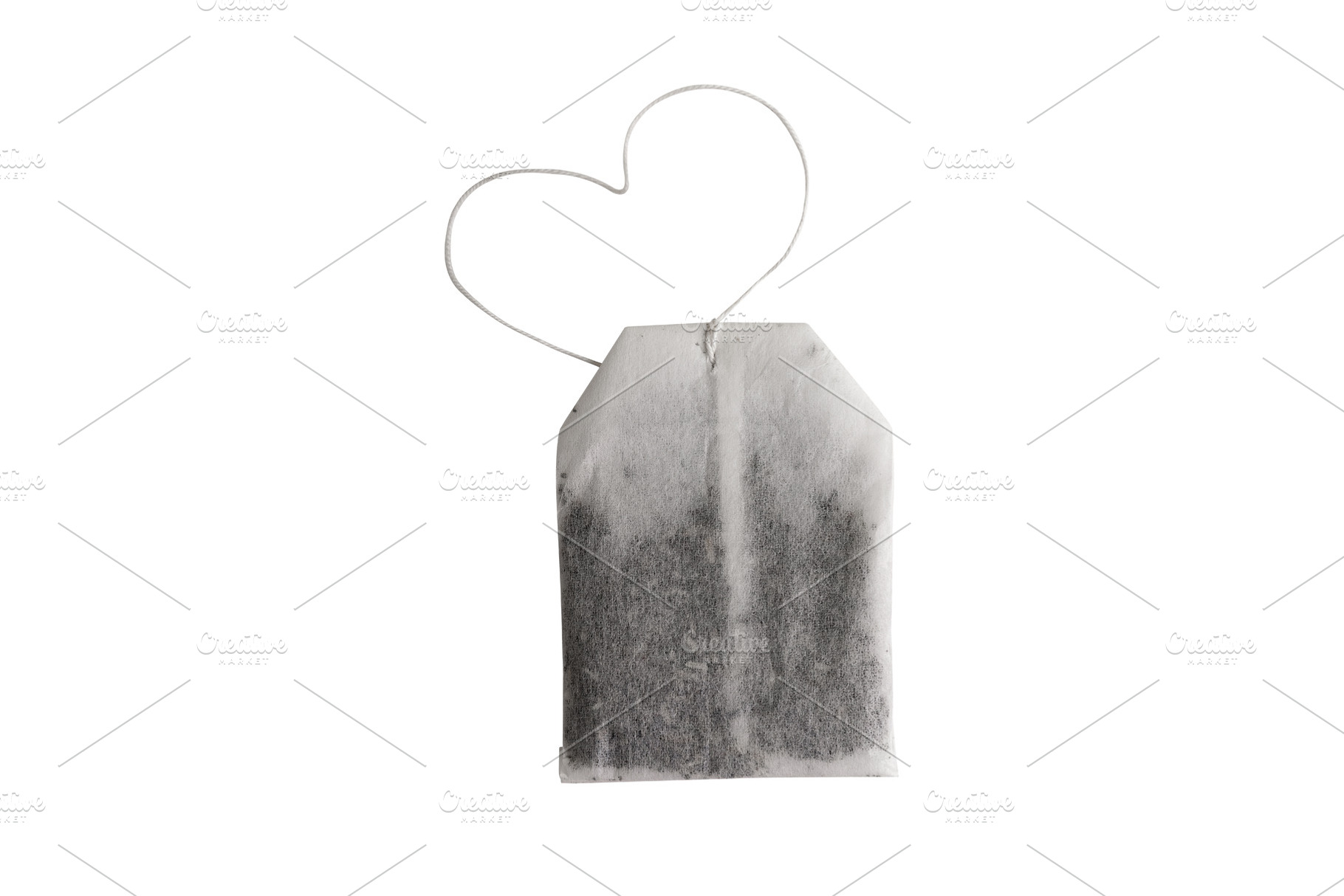 Single tea bag with a heart-shaped string isolated on white, sym, a Food & Drink Photo by Ales Munt