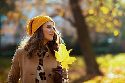 pensive young 40 years old woman in brown coat and yellow hat, a Person Photo by Alliance Images