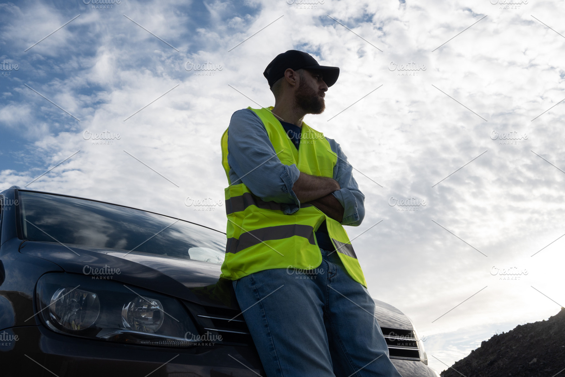 Young man wearing reflective vest beside broken-down car on roadside, a Person Photo by etorres69