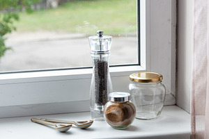 Spices and pepper mill on a windowsill