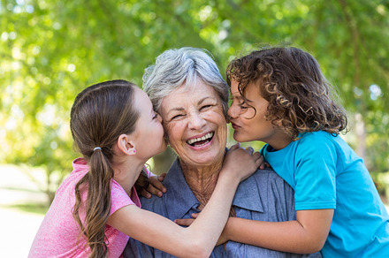 Extended family smiling and kissing in a park, a Photo by wavebreak