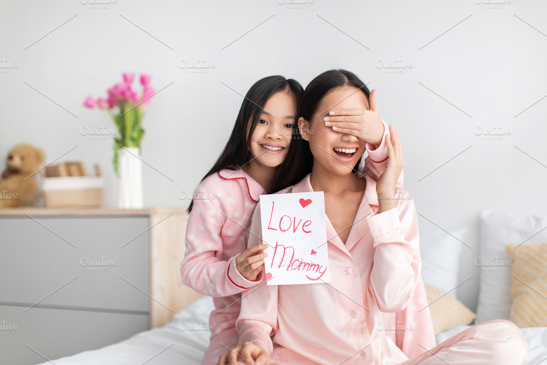 Satisfied chinese teenage girl closes eyes to young lady gives card and congrat, a Photo by Prostock-Studio