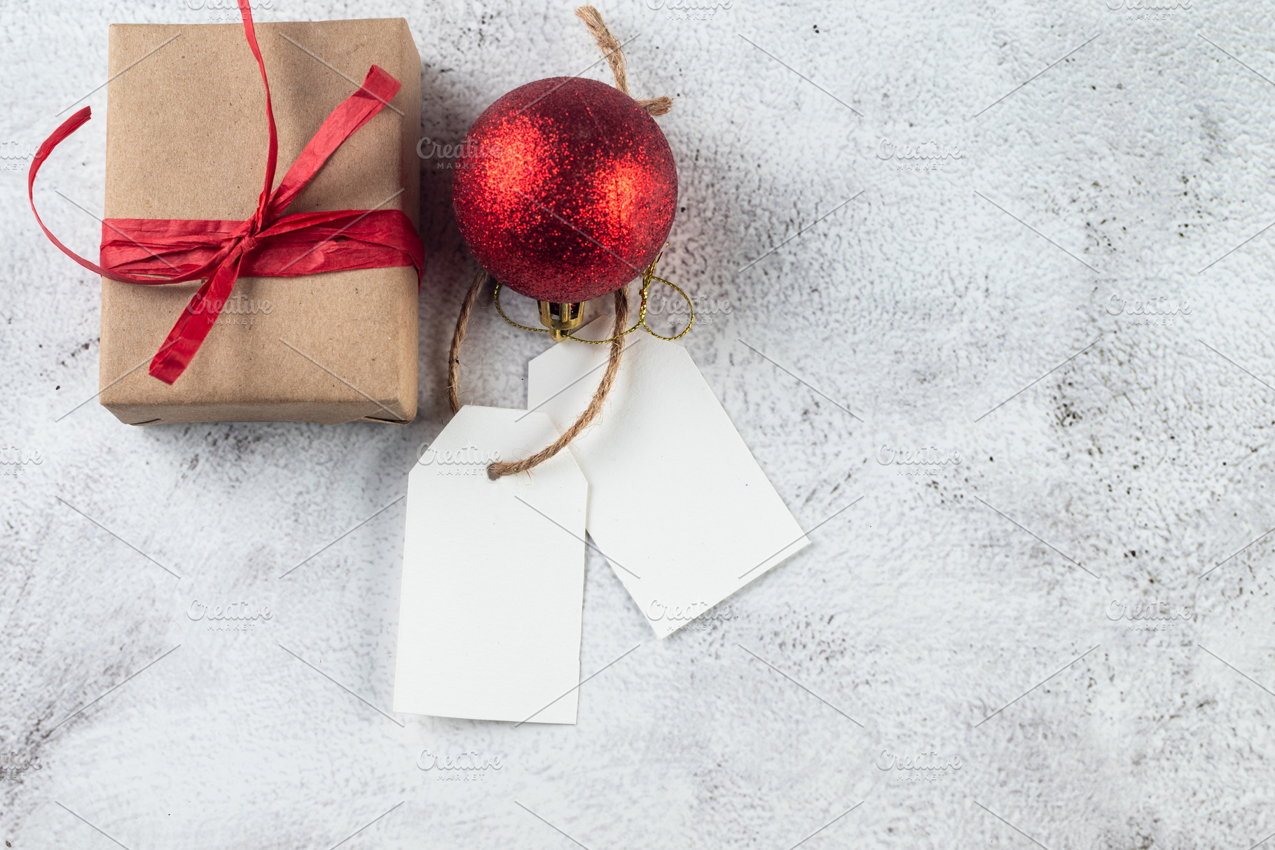 Empty tag with gifts and red Christmas decor on grey conkrete ba, a Holiday Photo by vimart