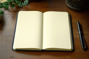 Open notebook on wooden table, a Photo by Pavel_design