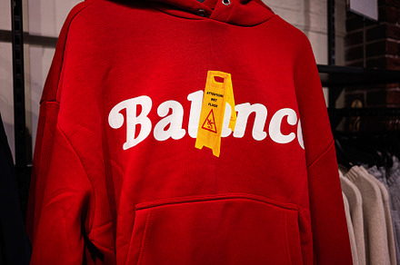 Closeup of a red hoodie with text and yellow novelty design, a Photo by AS photostudio