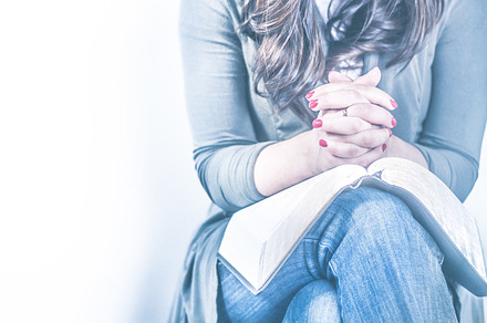 Women praying with open Bible