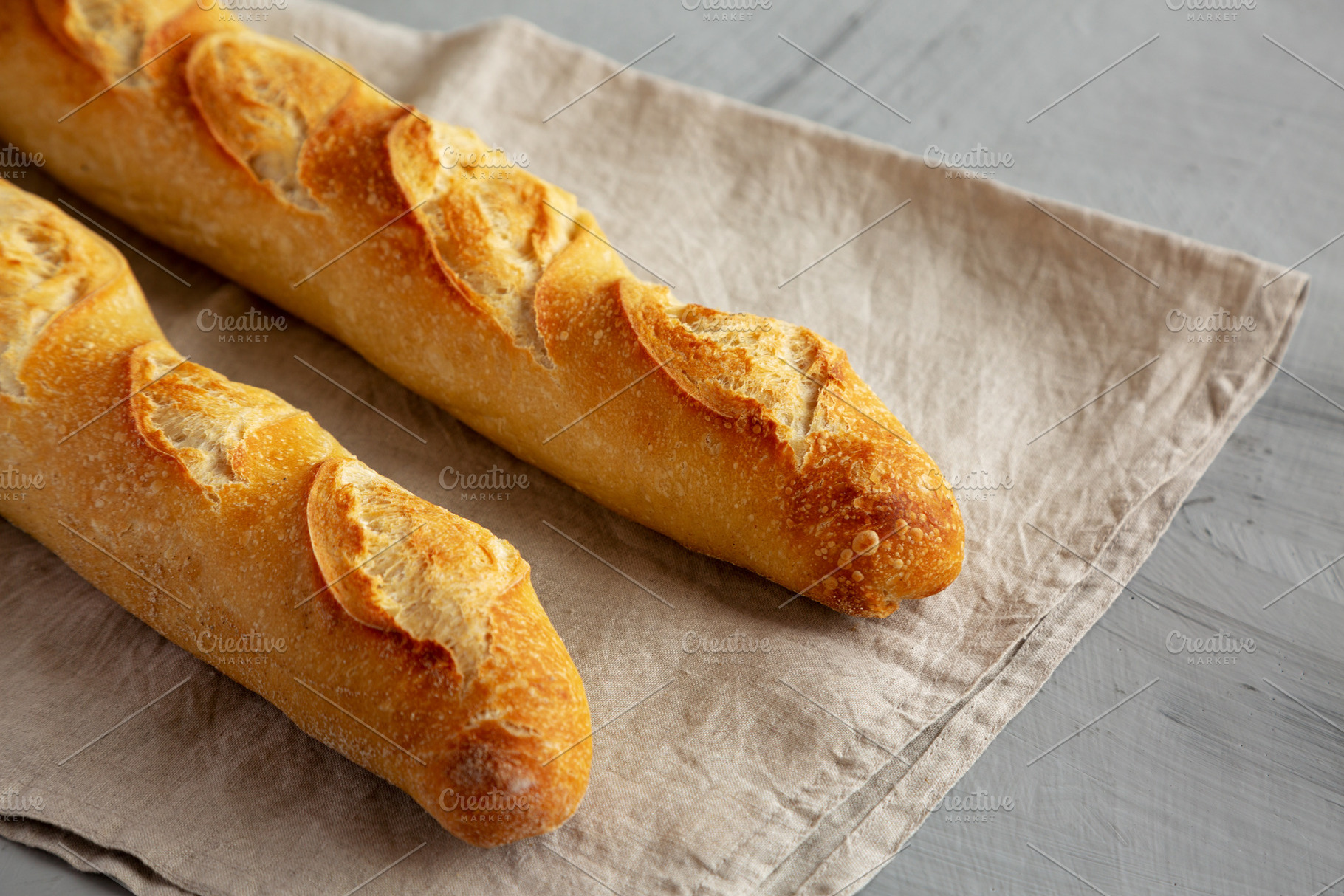 Homemade French Bread Baguette on a gray background, side view., a Food & Drink Photo by LiudmylaChuhunova