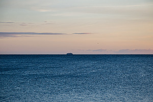 Serene ocean view during sunset with distant vessel near Iceland's horizon, a Nature Photo by AS photostudio