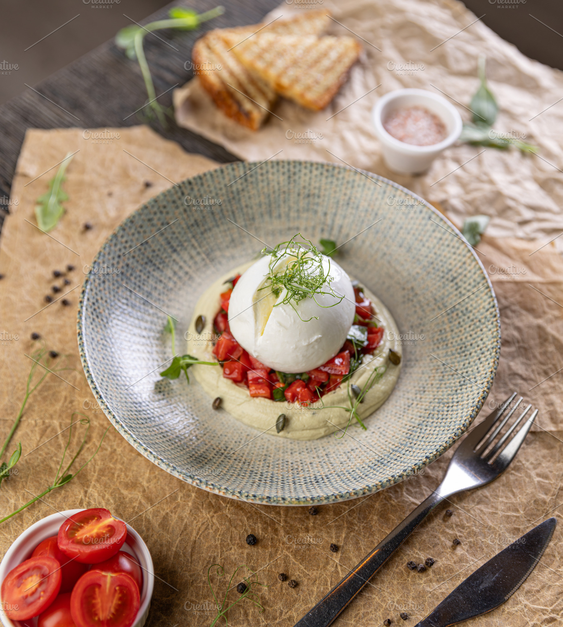 Burrata cheese resting on hummus, a Photo by Grafvision photography