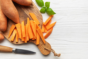 Preparing raw sweet potato fries on cutting board, a Food & Drink Photo by Olena Rudo