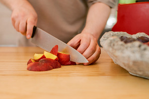 Hand cutting peach fruit preparation knife plums, a Food & Drink Photo by Photo Drive Studio