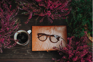 Reading glasses resting on notebook, a School & Education Photo by HalfPoint