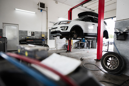 Car on hydraulic lift in modern auto repair shop, a Transportation Photo by AS photostudio