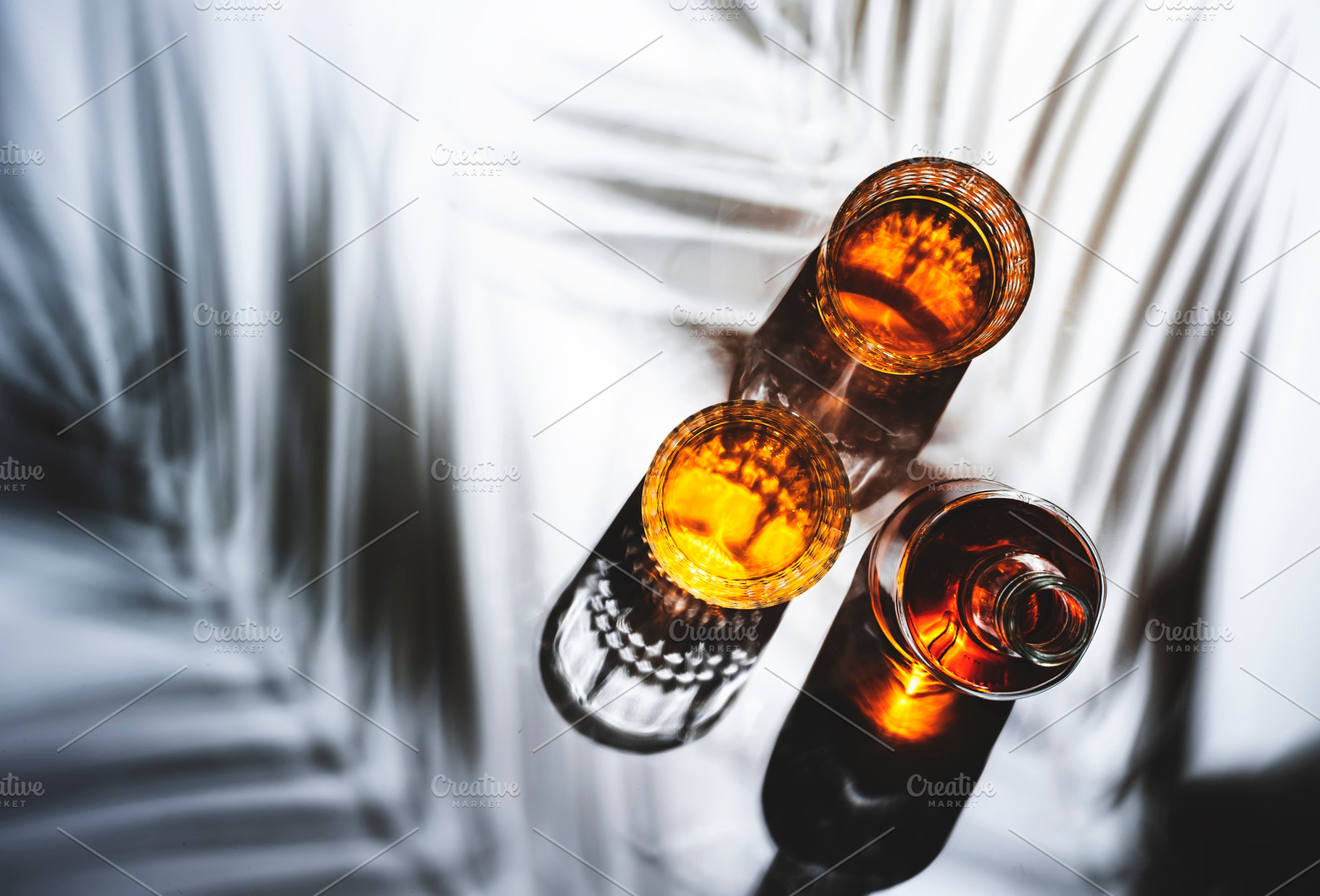 Whiskey in glasses and bottle, white background with hard light,, a Food & Drink Photo by 5PH