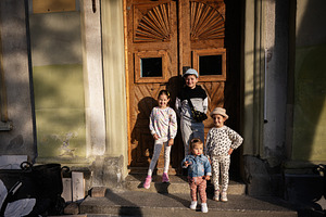 Group of cheerful children posing in front of a wooden door outdoors, a Person Photo by AS photostudio