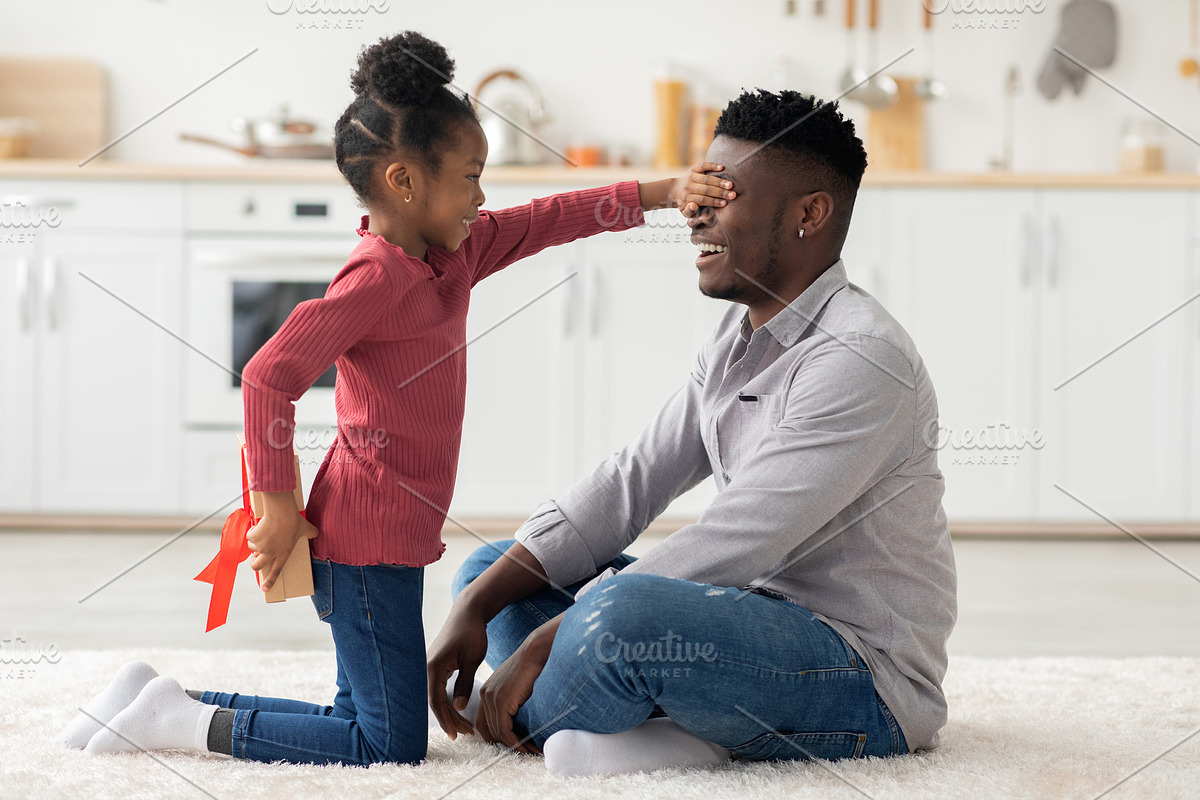 Cute little girl making birthday surprise for her dad, a Photo by Prostock-Studio (Photo 1 of 2)