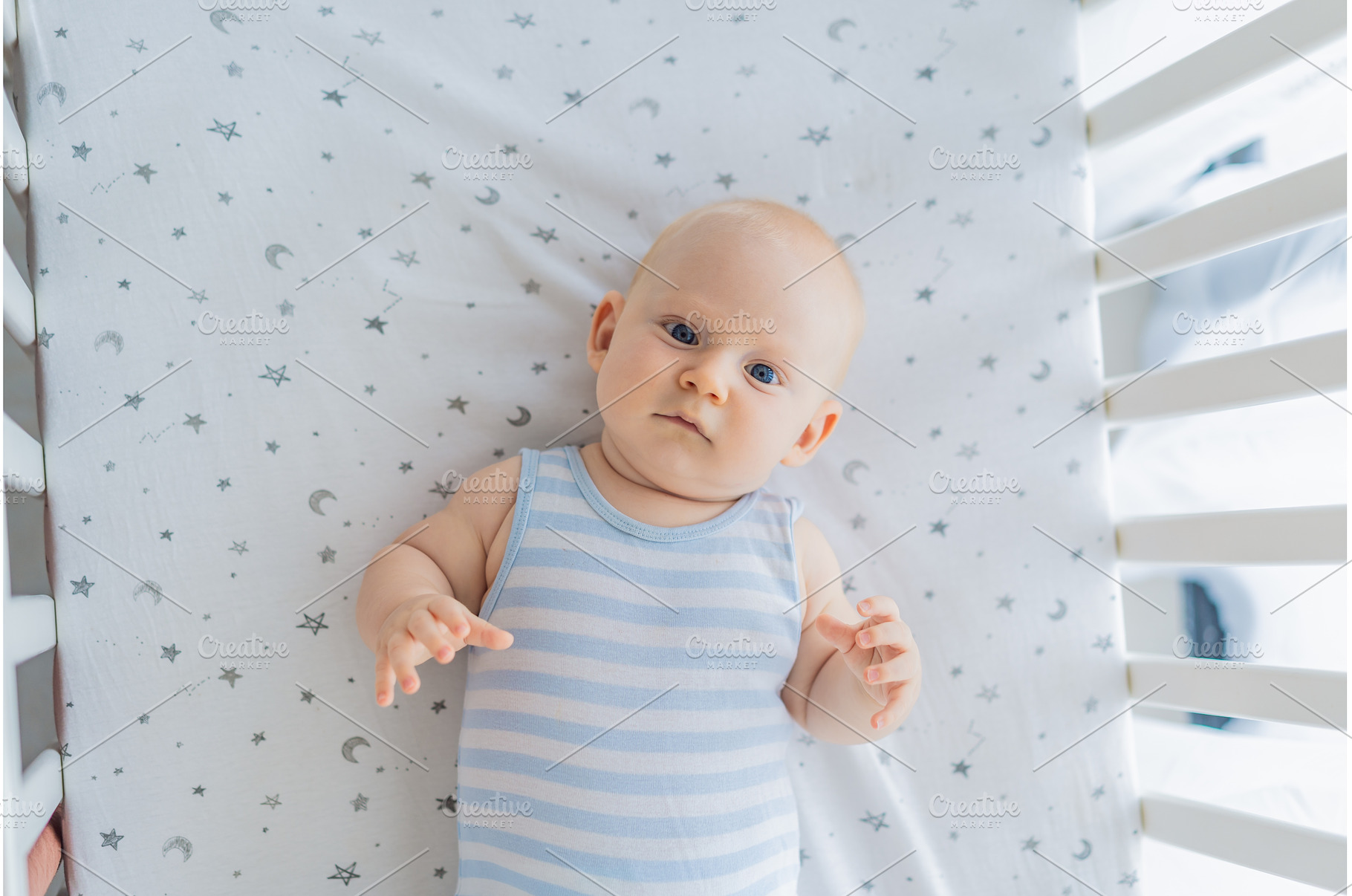 Baby lying peacefully in a cozy crib, a Person Photo by Elizaveta Galitskaya