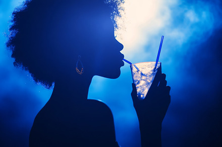Stylish Silhouettes Enjoying Refreshing Drinks in Neon Light