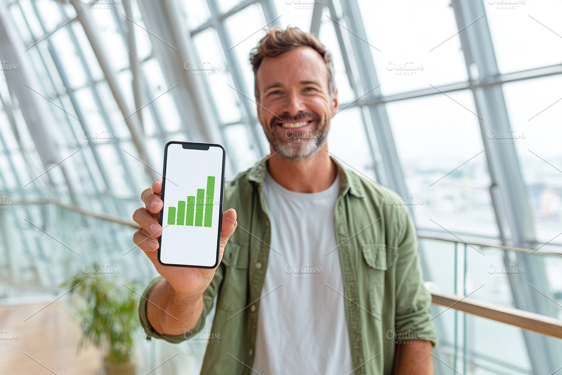 Young businessman celebrating success with smartphone display in modern office, a Business Photo by AlyaAnd
