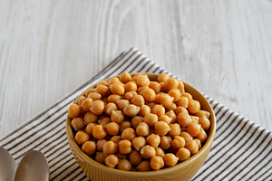 Organic Raw Canned Chickpeas in a Bowl, side view. Space for tex, a Food & Drink Photo by LiudmylaChuhunova