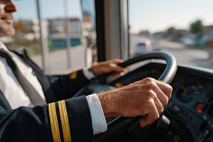 A senior male bus driver in uniform skillfully navigates city streets, showcasi, a Person Photo by ImageMir