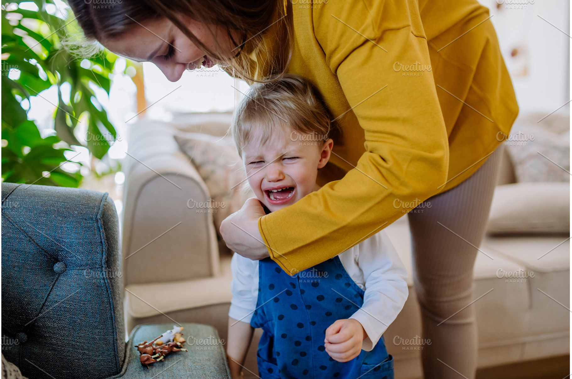 Mother consoling her little crying, a Person Photo by HalfPoint