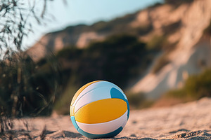 A bright volleyball sits on the soft, golden sand at a beach with a clear blue, a Sports & Recreation Photo by AlyaAnd