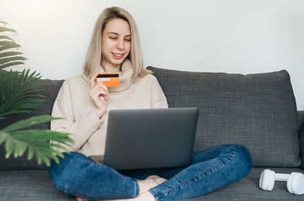 Young woman holding credit card and using laptop computer., a Business Photo by Olena Rudo