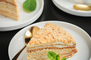 Medovik. Honey cake made from honey cakes with whipped sour cream, decorated wi, a Food & Drink Photo by Budarinphoto
